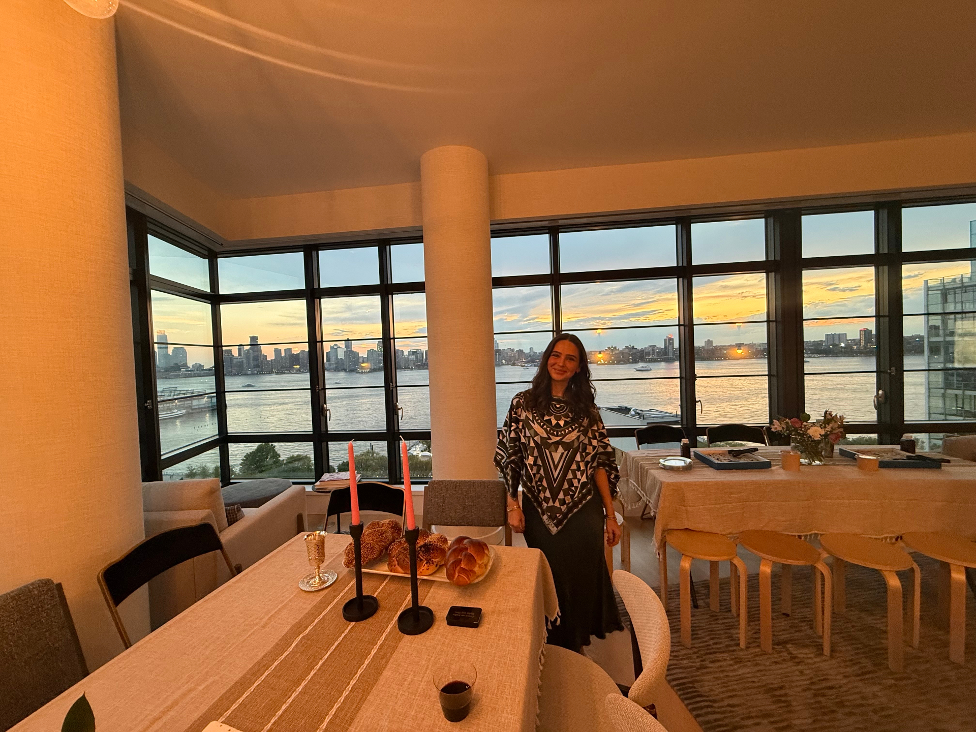 Founder of Heala at a Shabbat table overlooking the Hudson at sunset